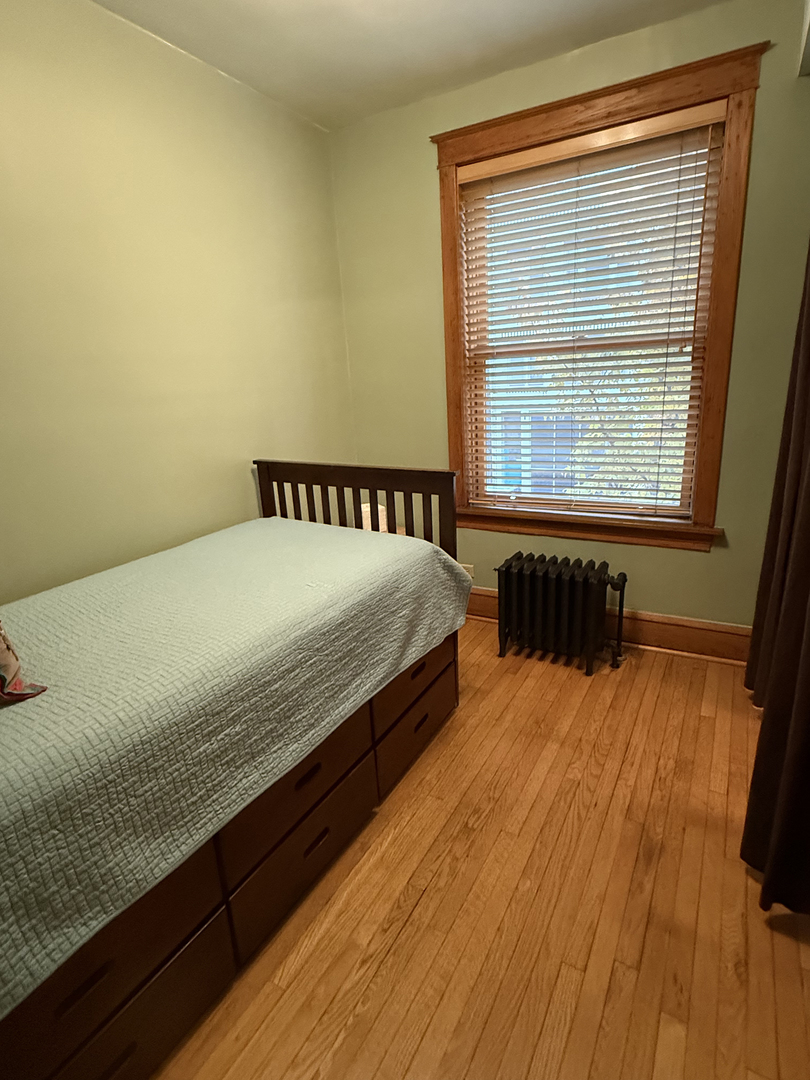 2134 North Damen Avenue, Unit 2 Chicago, IL 60647 - Photo 17 of 22 a bed sitting in a bedroom next to a window