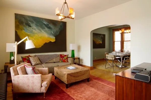 a living room with furniture a chandelier and a wooden floor