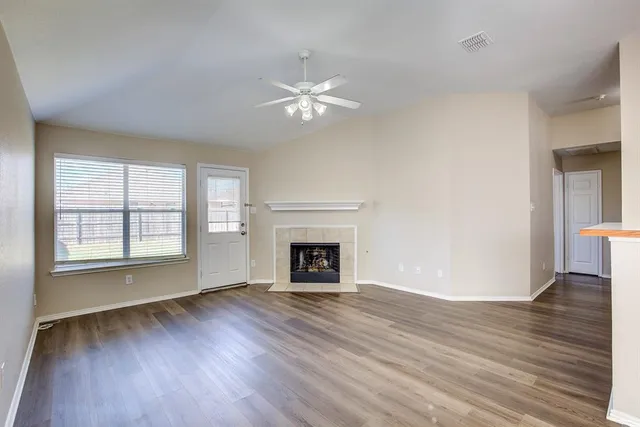 wooden floor fireplace and windows in an empty room