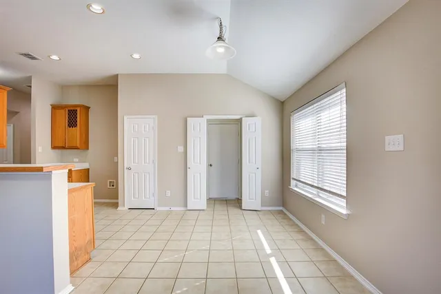 a view of an empty room with window and cabinet