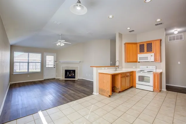 a large kitchen with granite countertop a stove top oven sink and cabinets