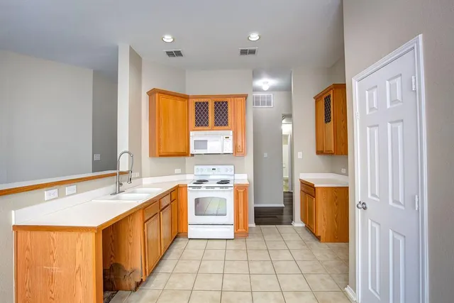 a spacious bathroom with a granite countertop sink a mirror and a bathtub