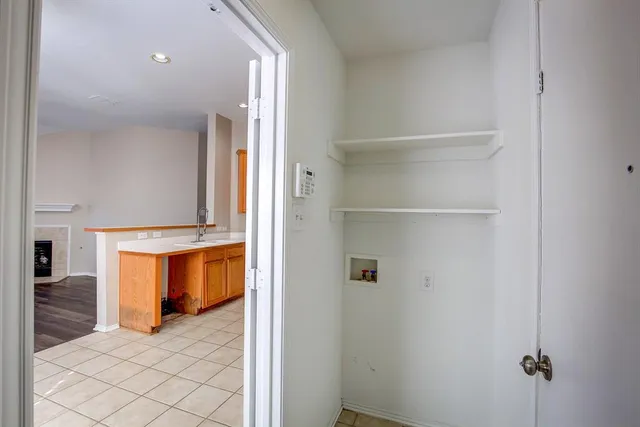 an empty room with windows and chandelier fan