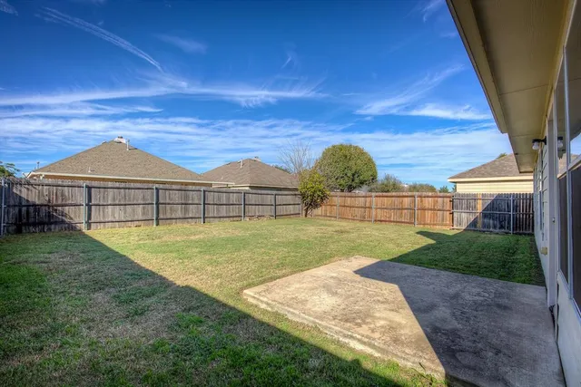 a view of backyard with swimming pool and seating space