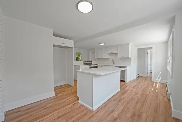 a kitchen with wooden floors and white walls