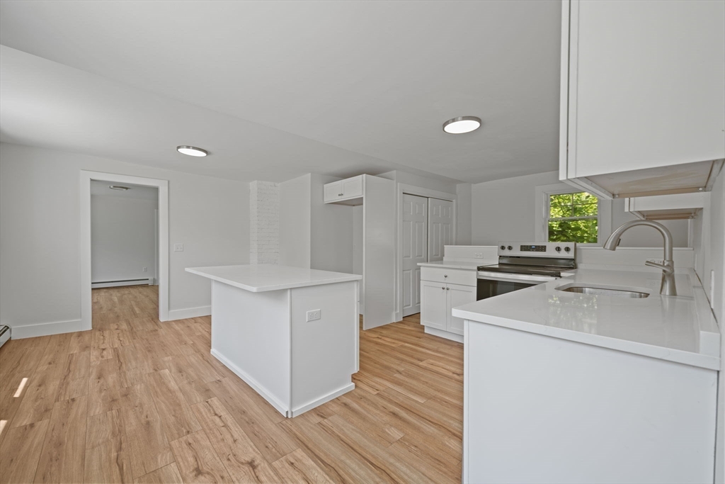 282 Parker Road Barnstable, MA 02668 - Photo 5 of 17 a kitchen with wooden floor sink and white appliances