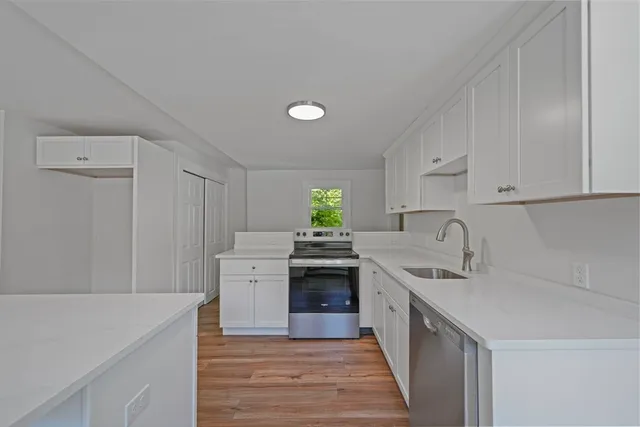 a kitchen with white cabinets and white appliances