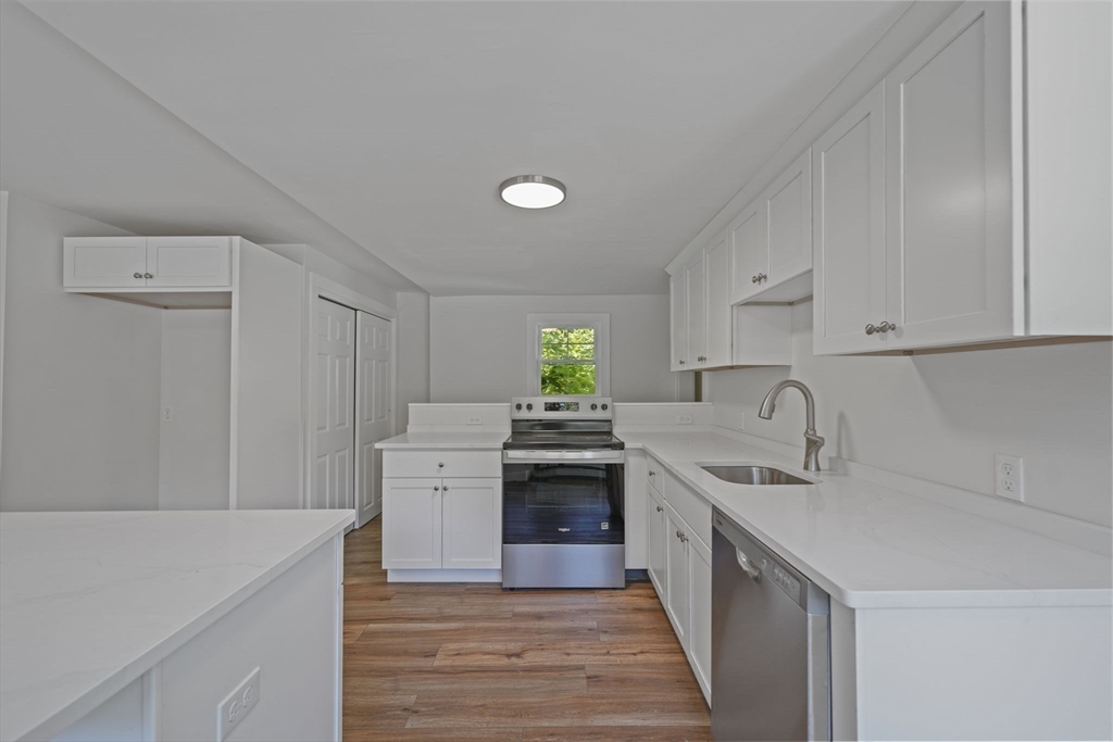 282 Parker Road Barnstable, MA 02668 - Photo 6 of 17 a kitchen with white cabinets and white appliances