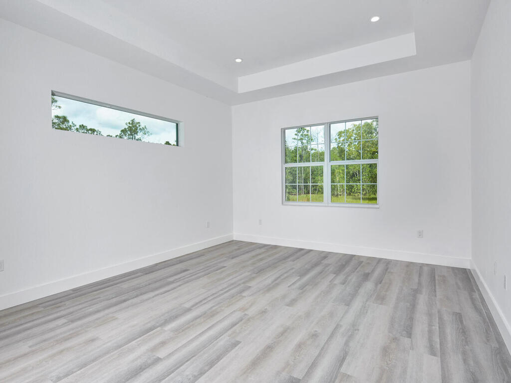 3677 Oil Well Road Naples, FL 34120 - Photo 10 of 28 wooden floor in an empty room with a window