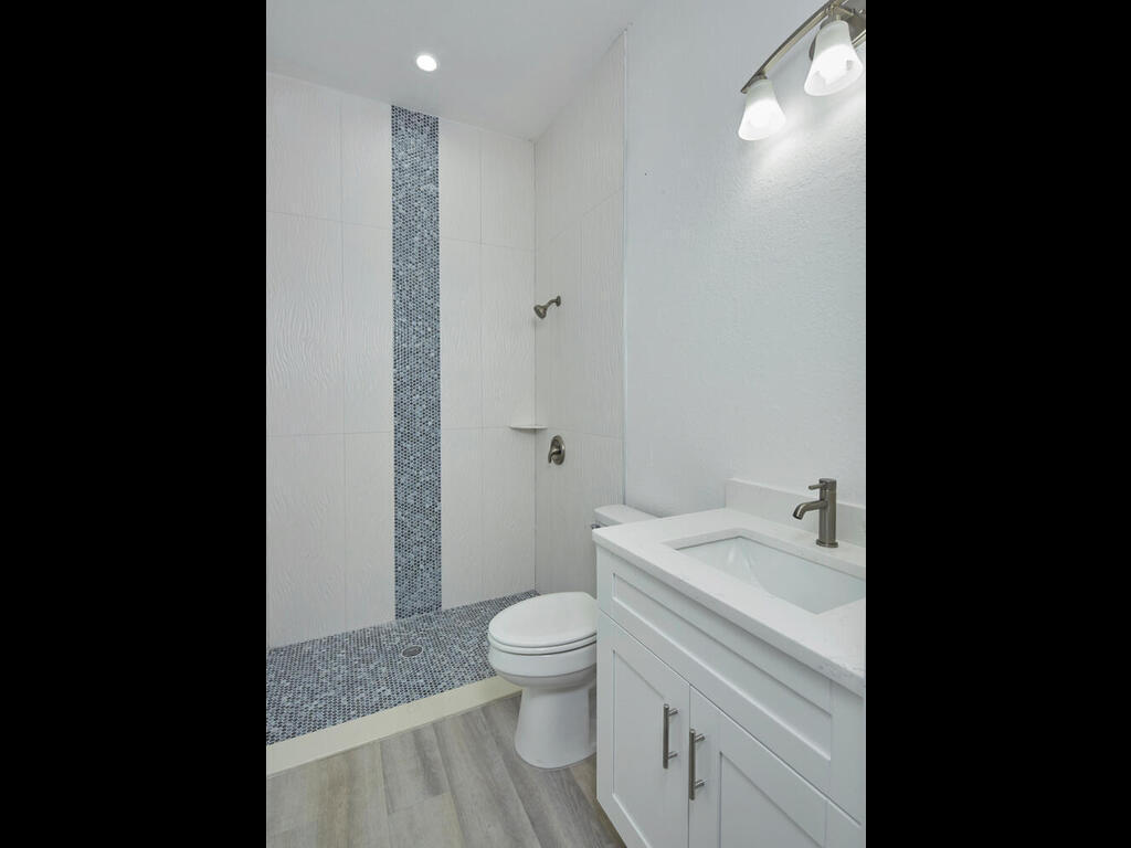 3677 Oil Well Road Naples, FL 34120 - Photo 17 of 28 a bathroom with a sink a toilet and a large mirror