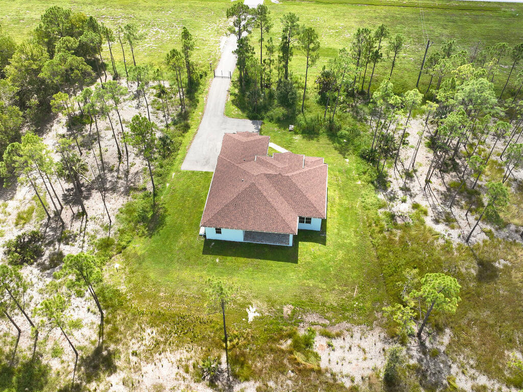 3677 Oil Well Road Naples, FL 34120 - Photo 26 of 28 a backyard of a house with large trees and plants