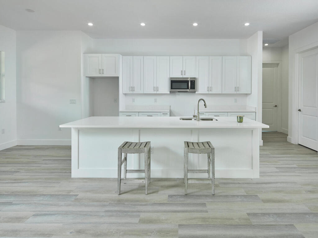 3677 Oil Well Road Naples, FL 34120 - Photo 6 of 28 a kitchen with stainless steel appliances granite countertop a white cabinets and wooden floor