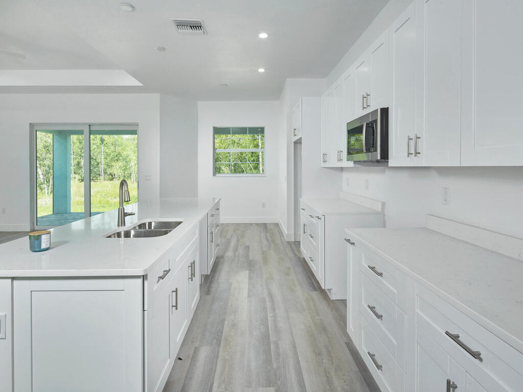 3677 Oil Well Road Naples, FL 34120 - Photo 7 of 28 a kitchen with a sink a window and cabinets