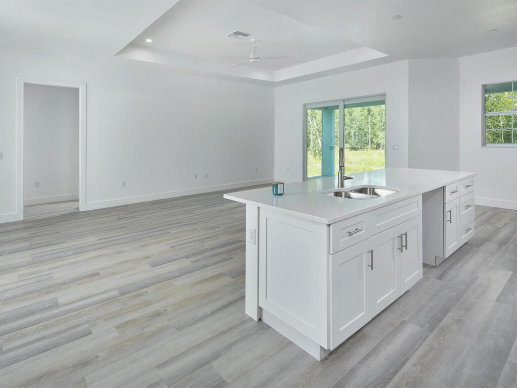 3677 Oil Well Road Naples, FL 34120 - Photo 8 of 28 a kitchen with a stove cabinets wooden floor and a window