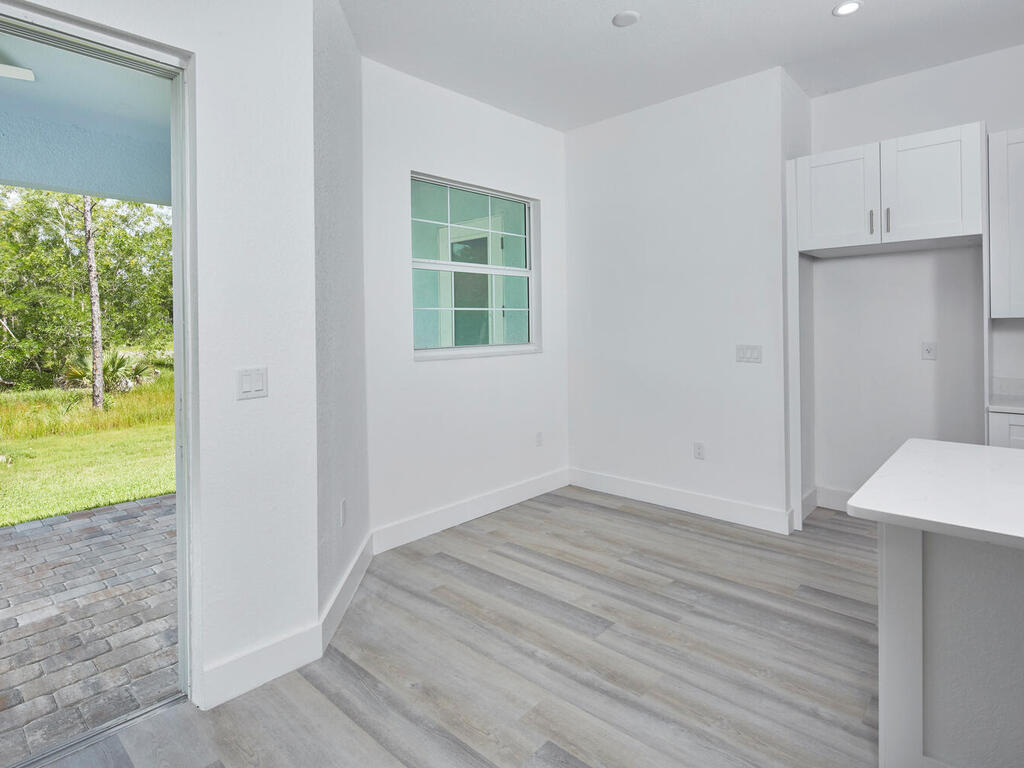 3677 Oil Well Road Naples, FL 34120 - Photo 9 of 28 an empty room with wooden floor and windows