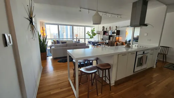 a dining room with stainless steel appliances granite countertop furniture wooden floor and a view of kitchen