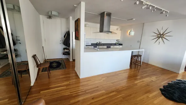 a kitchen with a wooden floor and a refrigerator