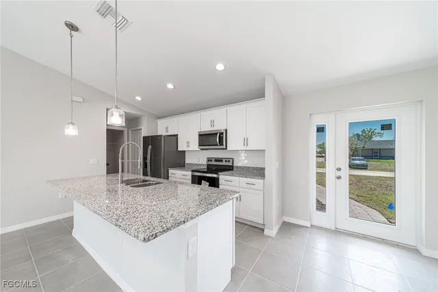 a kitchen with stainless steel appliances granite countertop a sink refrigerator and microwave