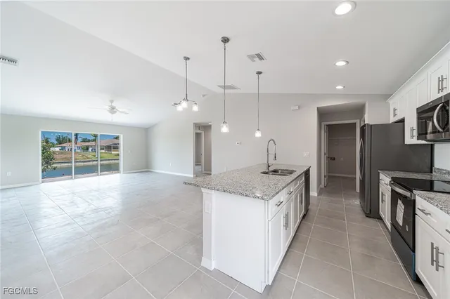 a kitchen with stainless steel appliances granite countertop a sink a stove and a wooden floors
