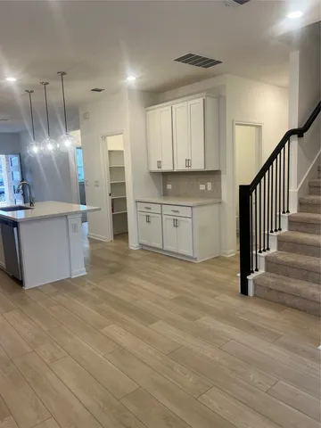 a view of a kitchen with wooden floor and stainless steel appliances