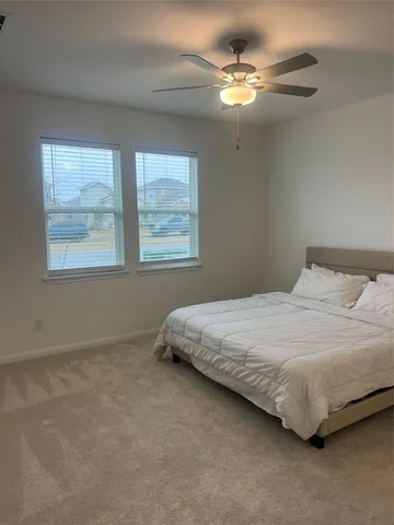 a bedroom with a bed chandelier and a window