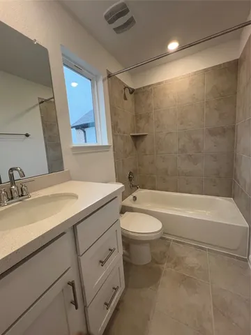 a bathroom with a granite countertop sink a toilet and shower