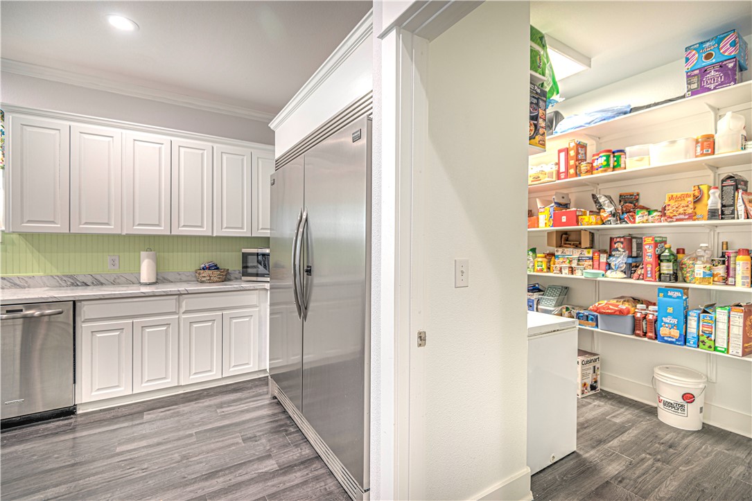 4948 Woodlawn Road Lorena, TX 76655 - Photo 20 of 48 a kitchen with stainless steel appliances cabinets and a wooden floor