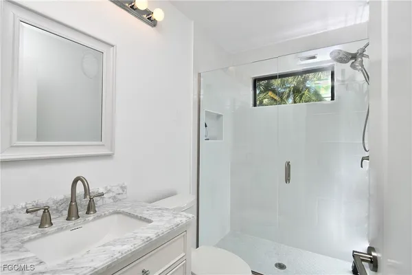 a bathroom with a granite countertop sink toilet and shower