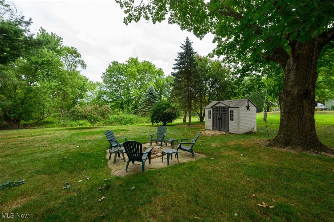 2667 Deibel Road Clinton, OH 44216 - Photo 3 of 23 View of yard with an outbuilding, a patio area, and a fire pit