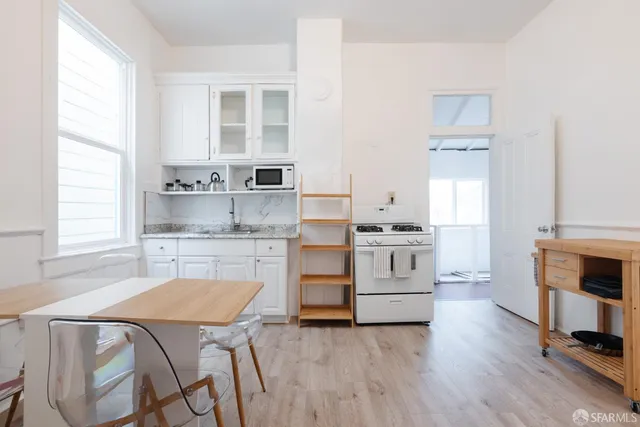 a kitchen with a stove cabinets and wooden floor