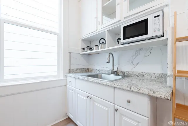 a kitchen with stainless steel appliances granite countertop a sink and a microwave