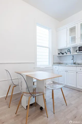 a kitchen with a table chairs sink and cabinets