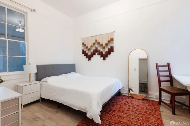 a bedroom with a bed table and a window