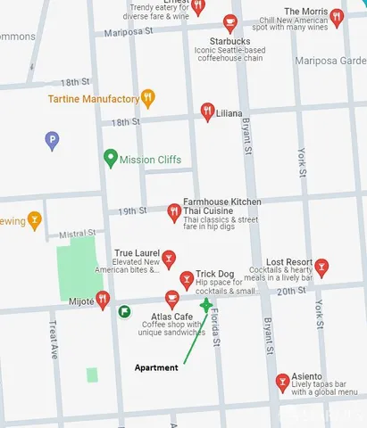 a utility room with a refrigerator and a bed