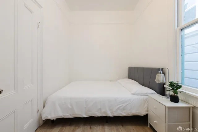a bedroom with a bed potted plant and a window