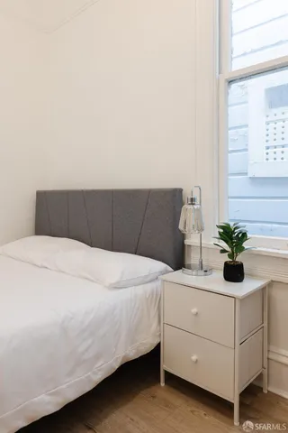 a bedroom with a bed and a potted plant