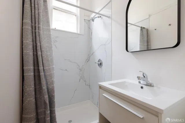 a bathroom with a sink a mirror and a shower