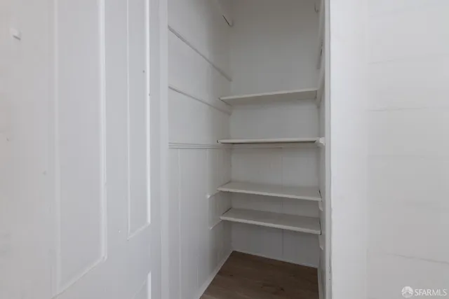 a view of walk in closet with empty racks