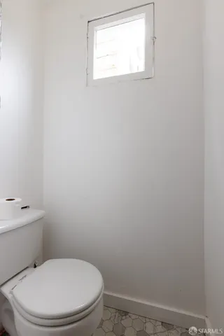 a white toilet sitting next to a window