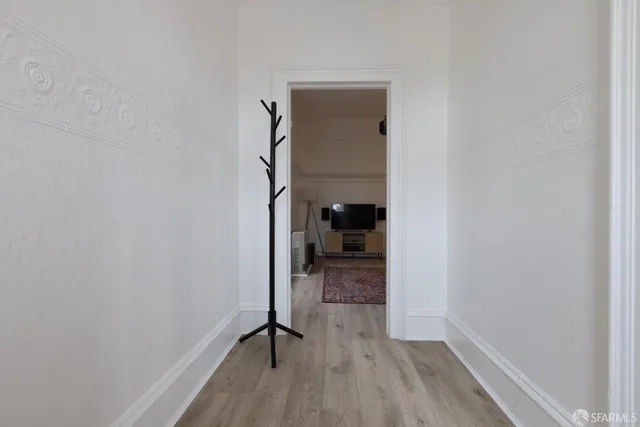 a view of a hallway with wooden floor and a closet