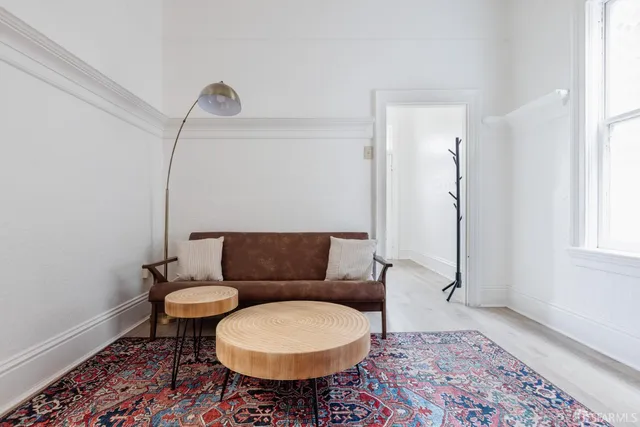 a living room with furniture a rug and a window