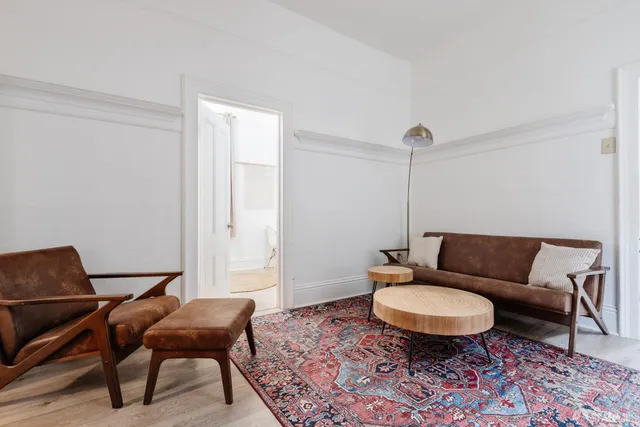 a living room with furniture a rug and a chair