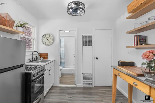 a view of a hallway with wooden floor and a chandelier fan