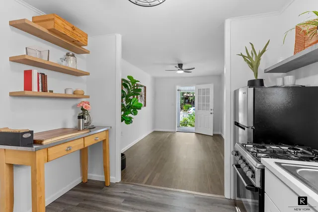 a kitchen with stainless steel appliances granite countertop a stove and a wooden floor