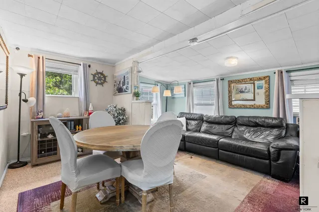 a living room with furniture two window and a table
