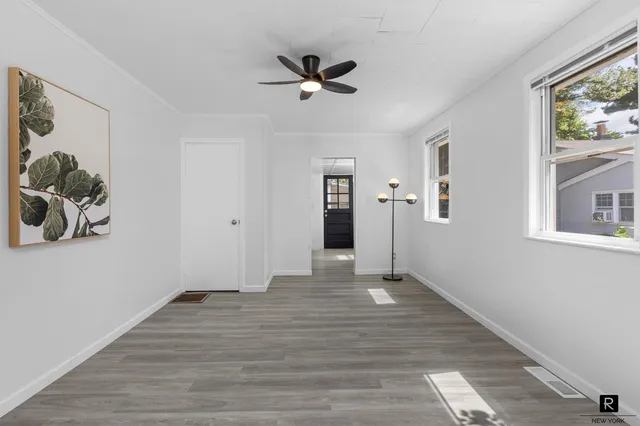 a view of empty room with wooden floor and window