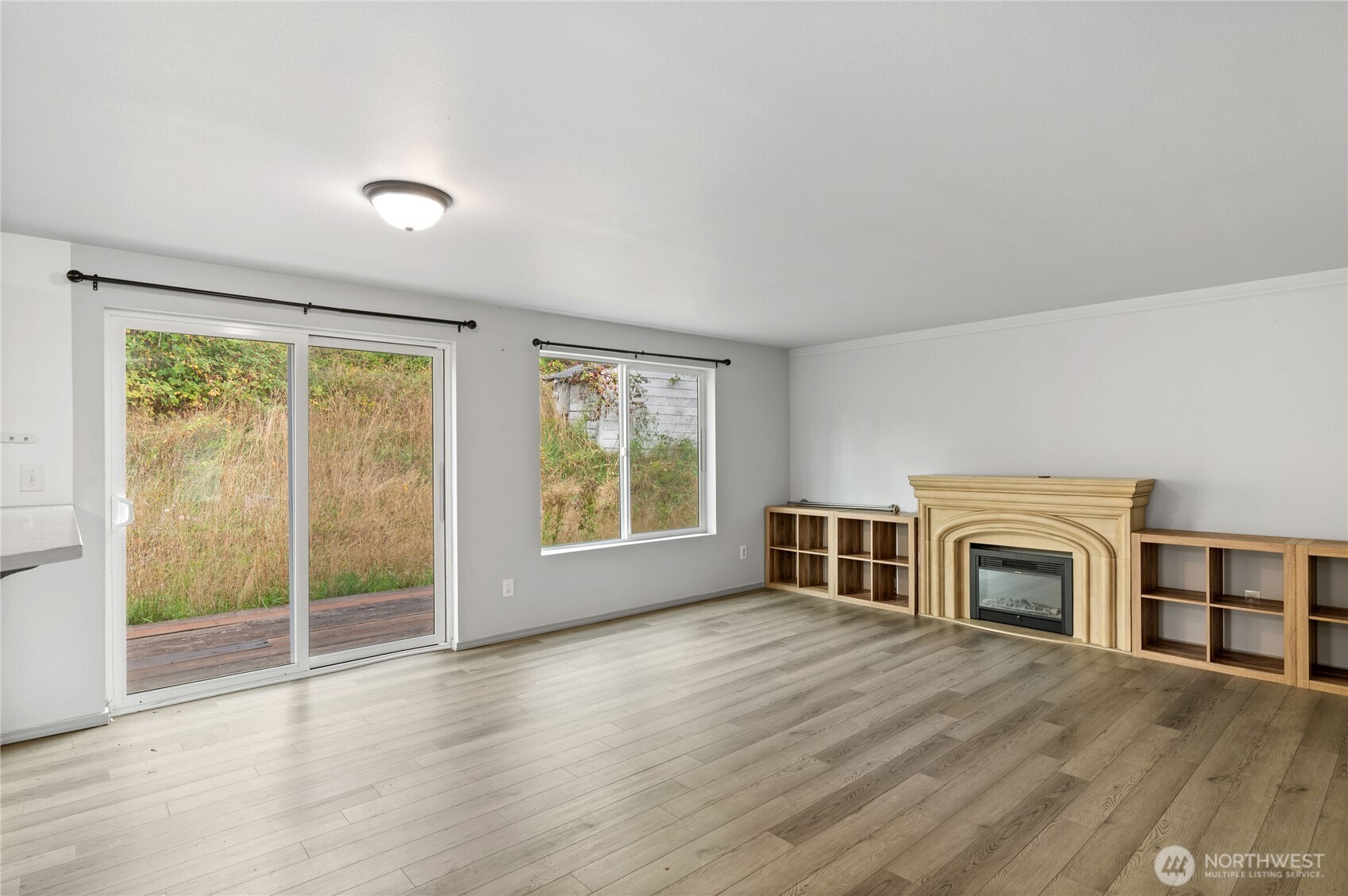 5151 East Pickering Road Shelton, WA 98584 - Photo 13 of 27 a view of a livingroom with a fireplace wooden floor and windows