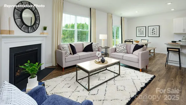 a living room with furniture a large window and a fireplace