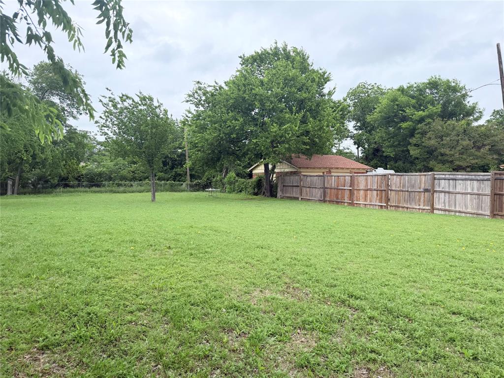 5633 Oak Grove Road Fort Worth, TX 76134 - Photo 2 of 7 a view of a backyard with a small cabin