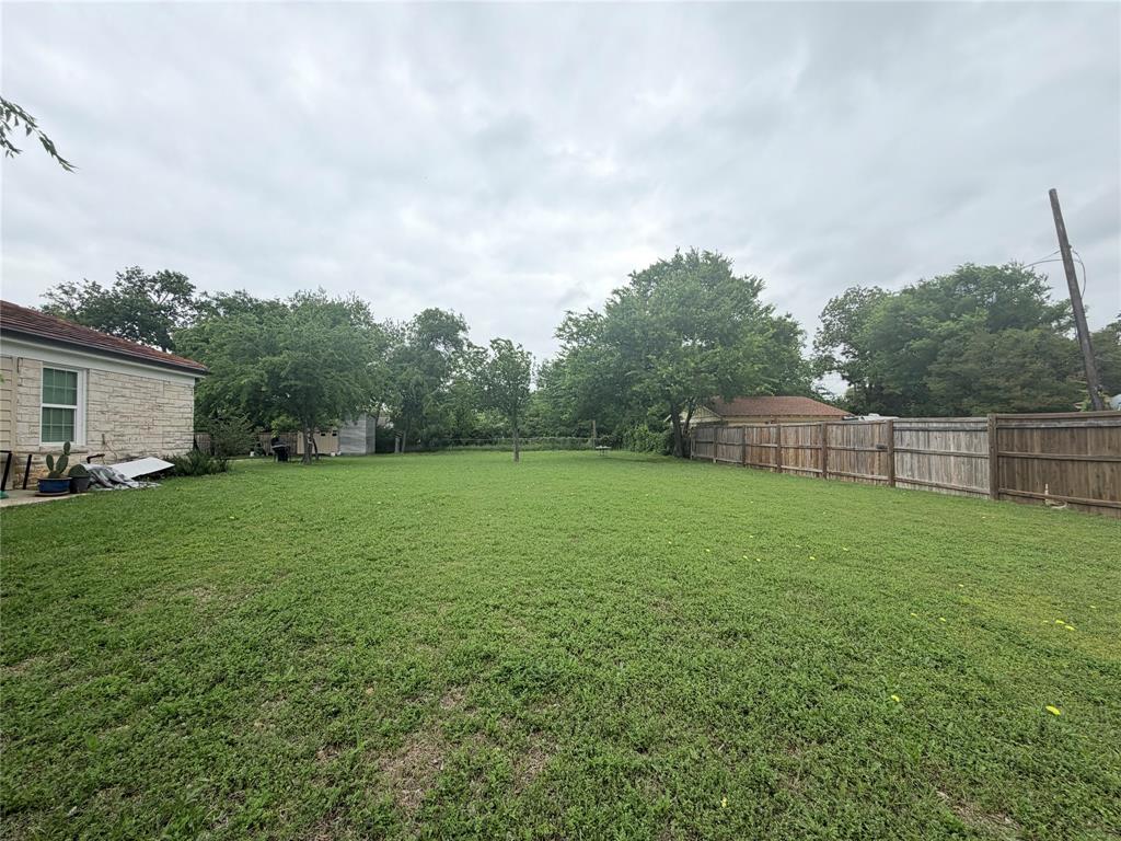 5633 Oak Grove Road Fort Worth, TX 76134 - Photo 3 of 7 a view of a backyard with grass & fence